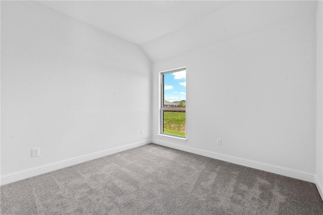 empty room with carpet flooring and vaulted ceiling