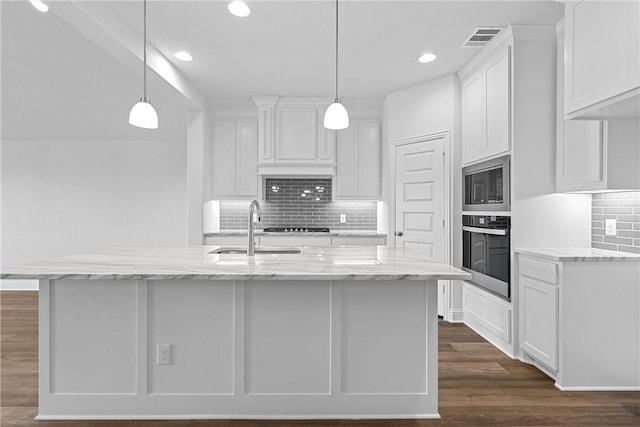 kitchen with a kitchen island with sink, stainless steel oven, and white cabinets