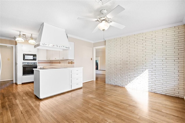 kitchen featuring kitchen peninsula, custom exhaust hood, black appliances, white cabinets, and light hardwood / wood-style floors