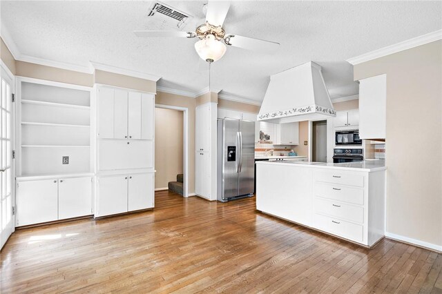 kitchen with ceiling fan, light hardwood / wood-style flooring, a textured ceiling, white cabinets, and black appliances