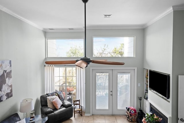 living area with plenty of natural light, french doors, crown molding, and ceiling fan