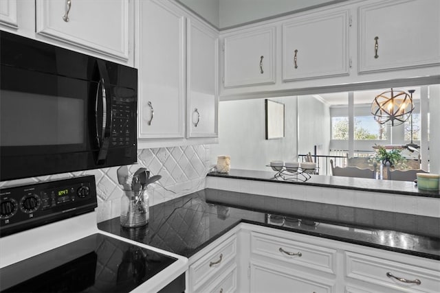 kitchen featuring a notable chandelier, backsplash, electric range oven, white cabinets, and black microwave