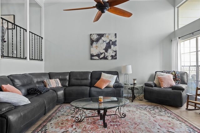 tiled living area with a towering ceiling and a ceiling fan