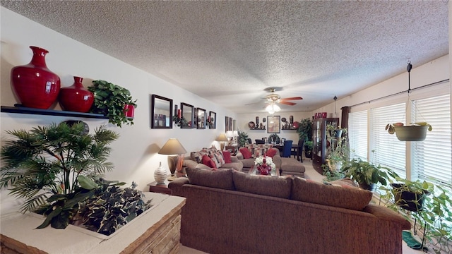 living room featuring ceiling fan and a textured ceiling