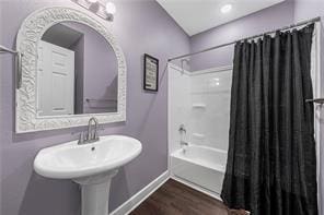 bathroom featuring hardwood / wood-style floors, sink, and shower / tub combo with curtain