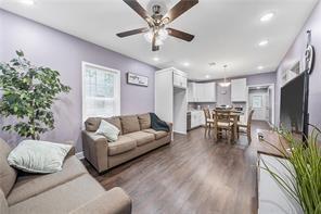 living room with ceiling fan and dark wood-type flooring