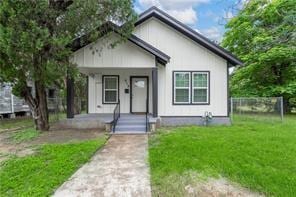 bungalow-style home featuring covered porch and a front lawn