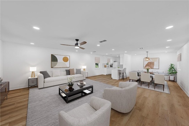 living room with ceiling fan and light hardwood / wood-style floors