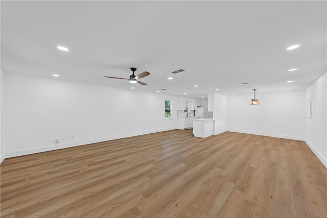 unfurnished living room with light wood-type flooring and ceiling fan