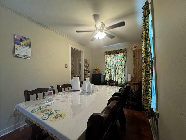 dining room featuring dark wood-type flooring, ceiling fan, and crown molding