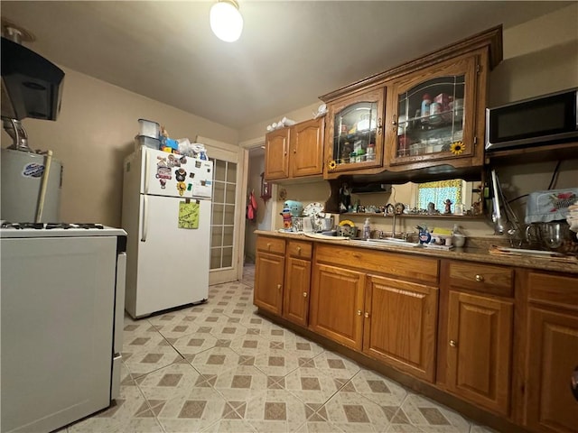 kitchen featuring white fridge, stove, and sink