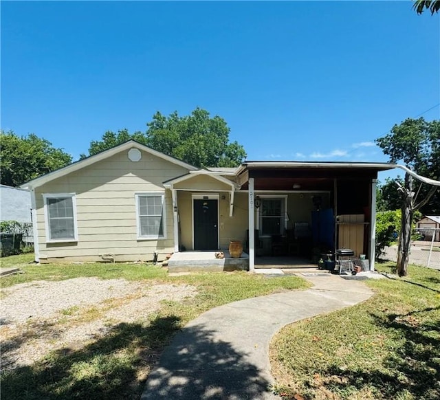 view of front of property with a front yard and a carport