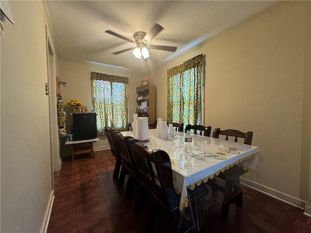 dining space with dark parquet floors, ceiling fan, and crown molding