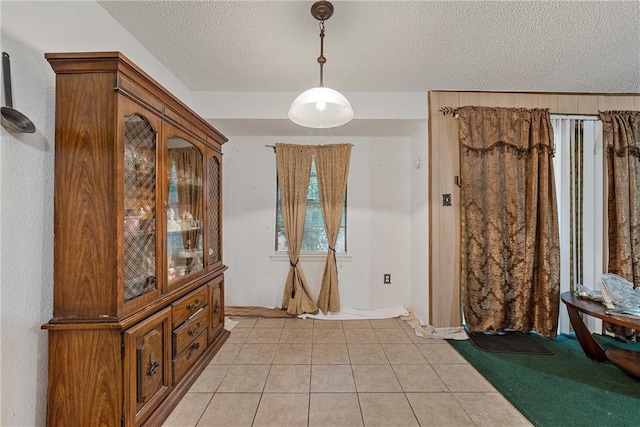 tiled entryway with a textured ceiling