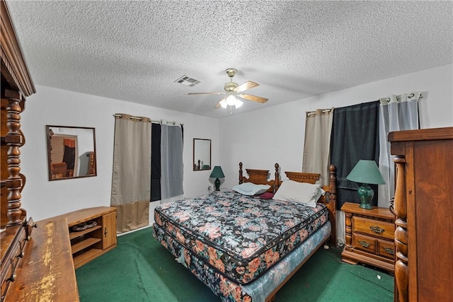 bedroom featuring ceiling fan, dark carpet, and a textured ceiling