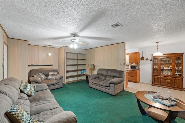 living room featuring ceiling fan, a textured ceiling, and light carpet