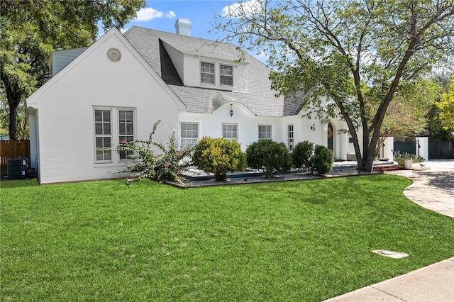 view of front facade with central air condition unit and a front lawn