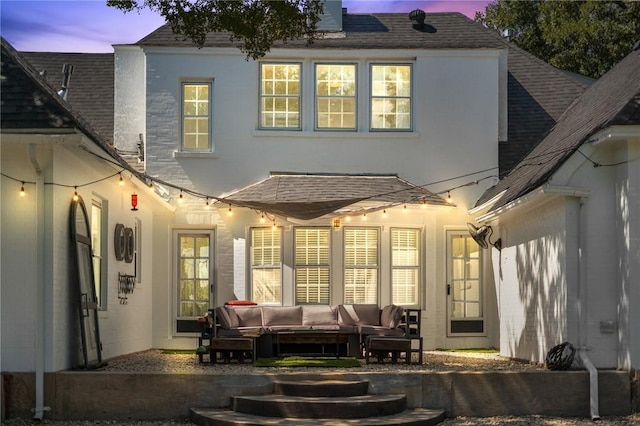 back house at dusk with outdoor lounge area