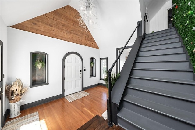 foyer entrance featuring high vaulted ceiling and dark hardwood / wood-style floors