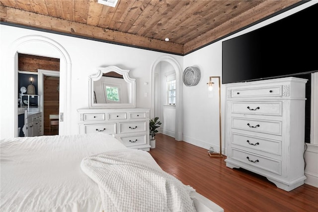 bedroom featuring beamed ceiling, wooden ceiling, and dark wood-type flooring