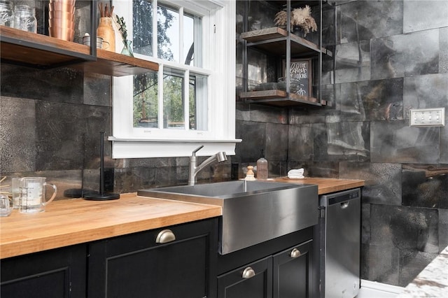 kitchen with decorative backsplash, stainless steel dishwasher, and sink