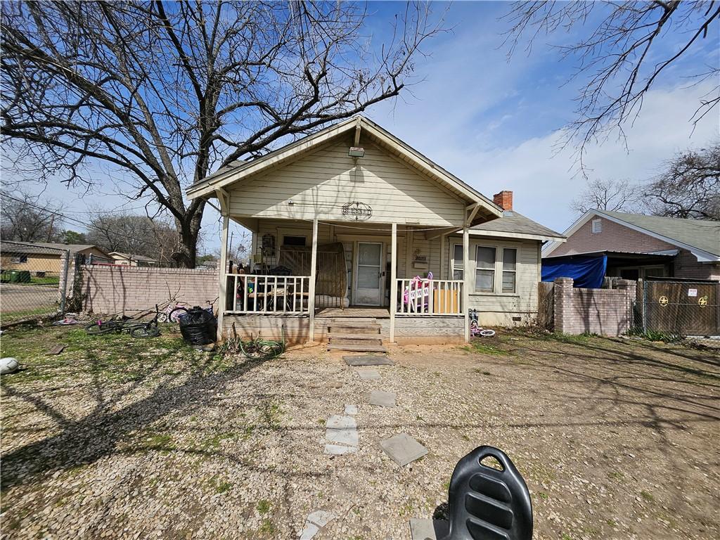 bungalow with covered porch, crawl space, a chimney, and fence