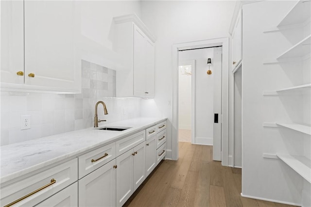 kitchen with high quality appliances, white cabinets, light hardwood / wood-style flooring, a barn door, and custom range hood