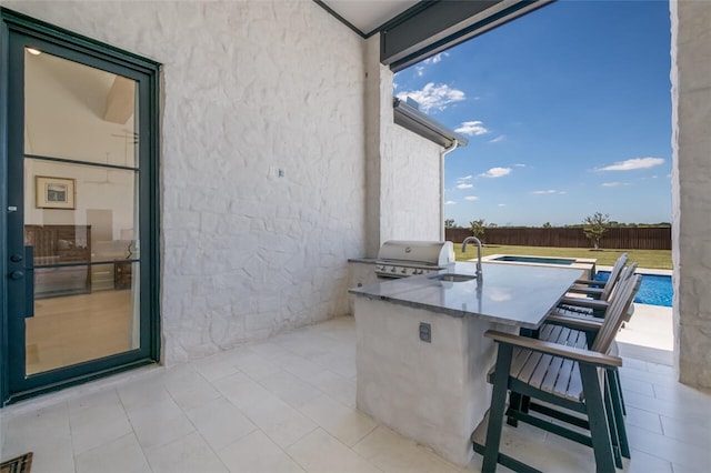 view of patio / terrace with a fenced in pool, a grill, area for grilling, and a wet bar