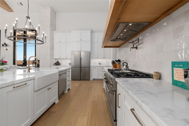 kitchen with appliances with stainless steel finishes, light hardwood / wood-style flooring, and white cabinetry