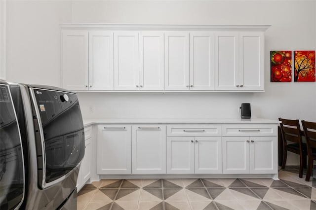 laundry room featuring washing machine and dryer and cabinets