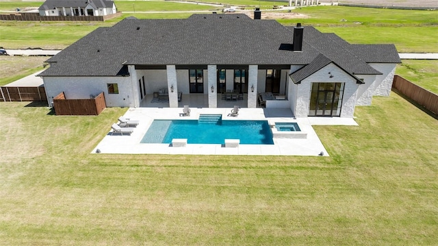 rear view of property with outdoor lounge area, a swimming pool with hot tub, a yard, and a patio