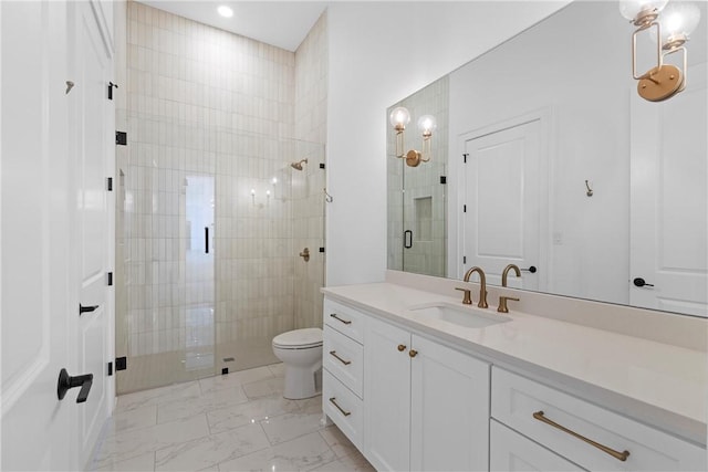 bathroom featuring vanity, toilet, and a shower with shower door