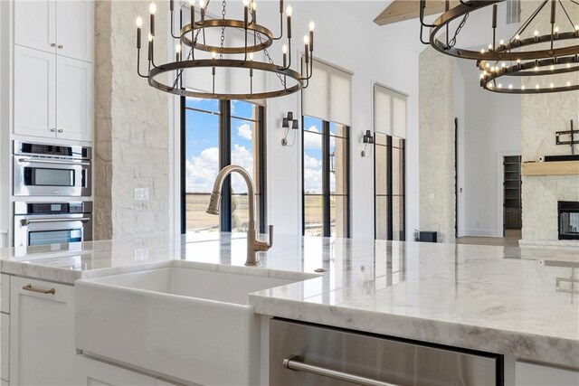 kitchen with backsplash, white cabinetry, range with two ovens, and light hardwood / wood-style floors