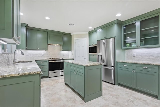 kitchen with light stone counters, a center island, stainless steel appliances, and green cabinetry