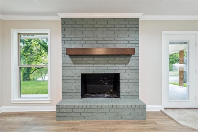 interior details with hardwood / wood-style flooring, crown molding, and a brick fireplace