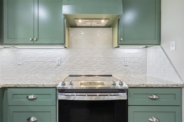 kitchen with tasteful backsplash, green cabinets, stainless steel electric range oven, and ventilation hood