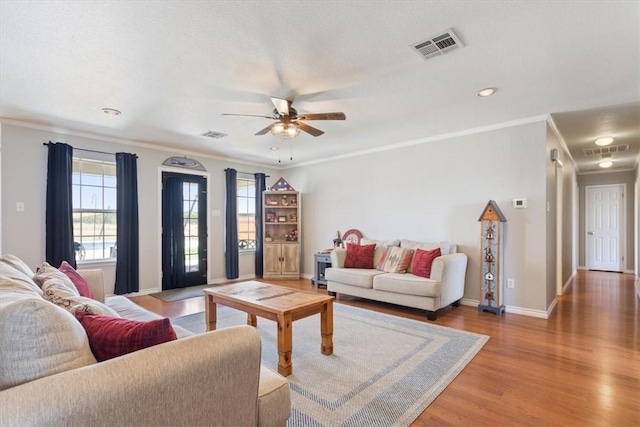 living room featuring hardwood / wood-style floors, ceiling fan, and ornamental molding