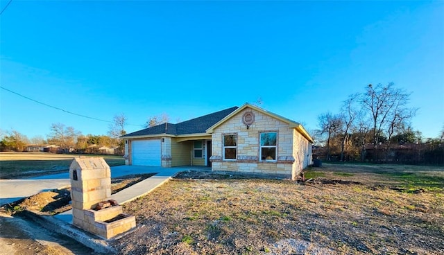 bungalow-style home with a garage, stone siding, and driveway