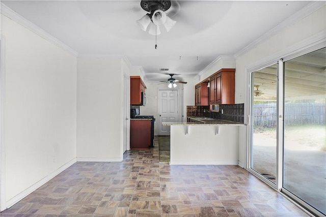 kitchen with kitchen peninsula, decorative backsplash, a breakfast bar, crown molding, and sink