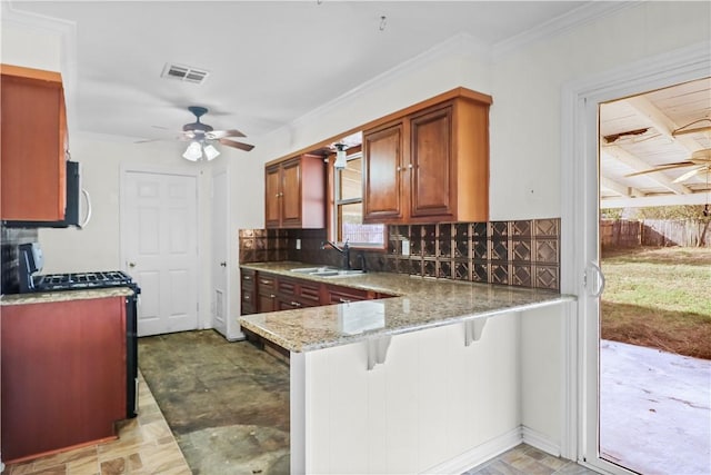 kitchen featuring sink, a kitchen breakfast bar, tasteful backsplash, light stone counters, and kitchen peninsula