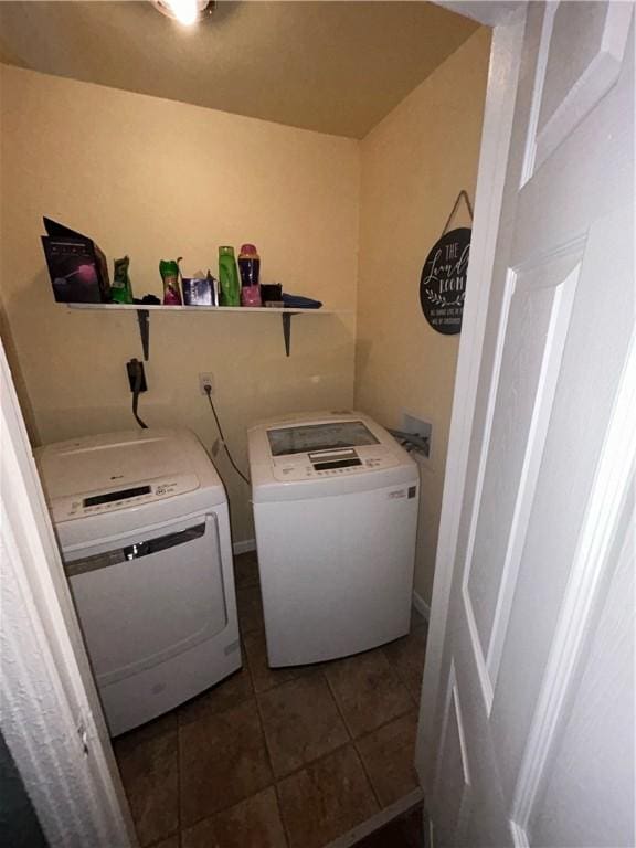 clothes washing area featuring laundry area, dark tile patterned floors, and separate washer and dryer