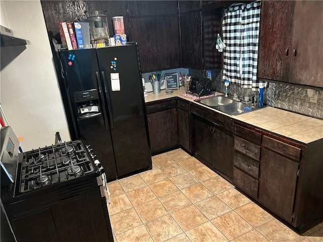 kitchen featuring a sink, tile countertops, dark brown cabinetry, and black refrigerator with ice dispenser