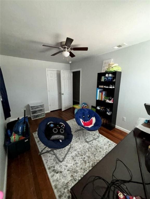 recreation room with ceiling fan, wood finished floors, visible vents, and baseboards