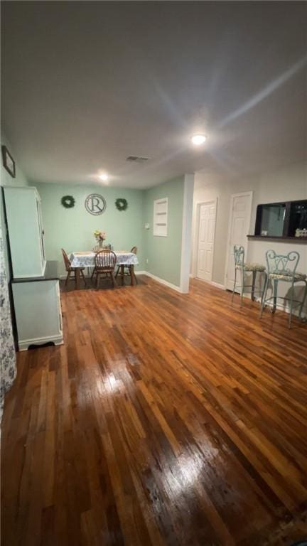 unfurnished living room featuring dark wood finished floors and baseboards