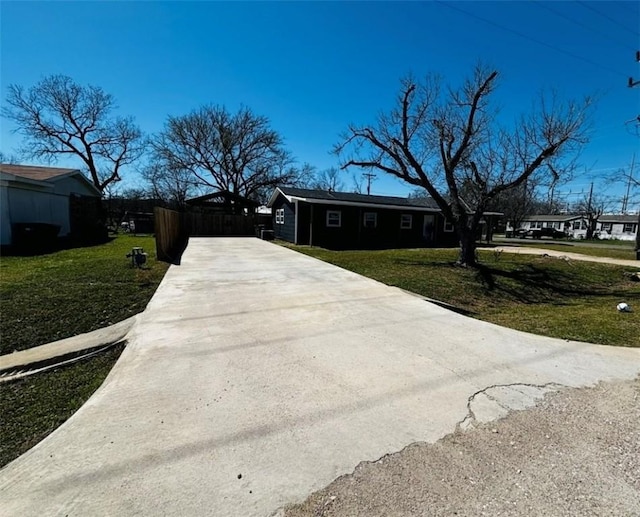 view of front of property with concrete driveway and a front lawn