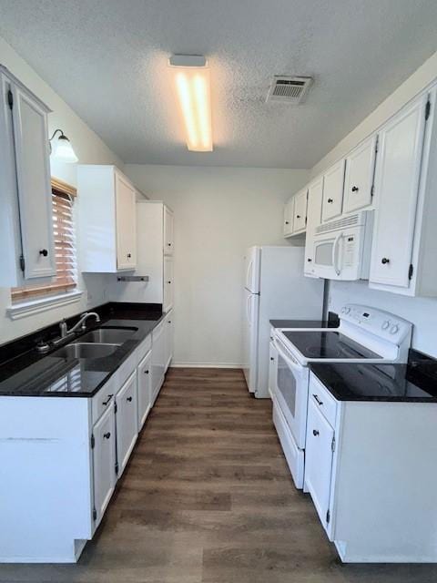 kitchen with a textured ceiling, white cabinets, and white appliances