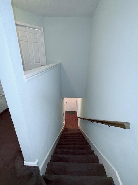 stairs with a textured ceiling