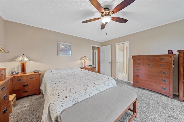 carpeted bedroom with a textured ceiling, ceiling fan, and ornamental molding