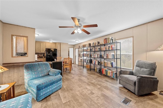 living area with ceiling fan and light hardwood / wood-style flooring