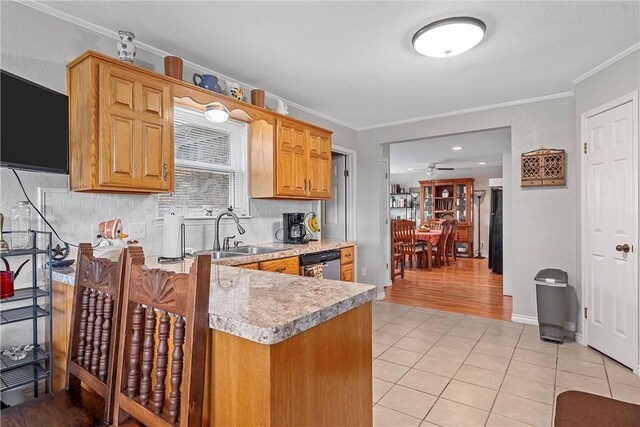 kitchen featuring light tile patterned floors, stainless steel dishwasher, ornamental molding, and sink